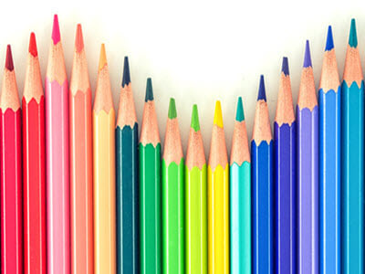 a line of colored pencils in varying heights arranged by colors of the rainbow