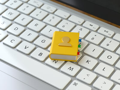 computer keyboard with a small yellow book on top