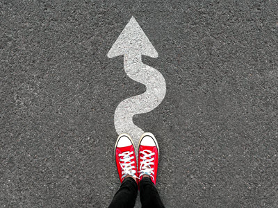 person wearing red sneakers standing on a squiggly arrow