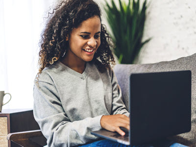 person smiling and using a laptop