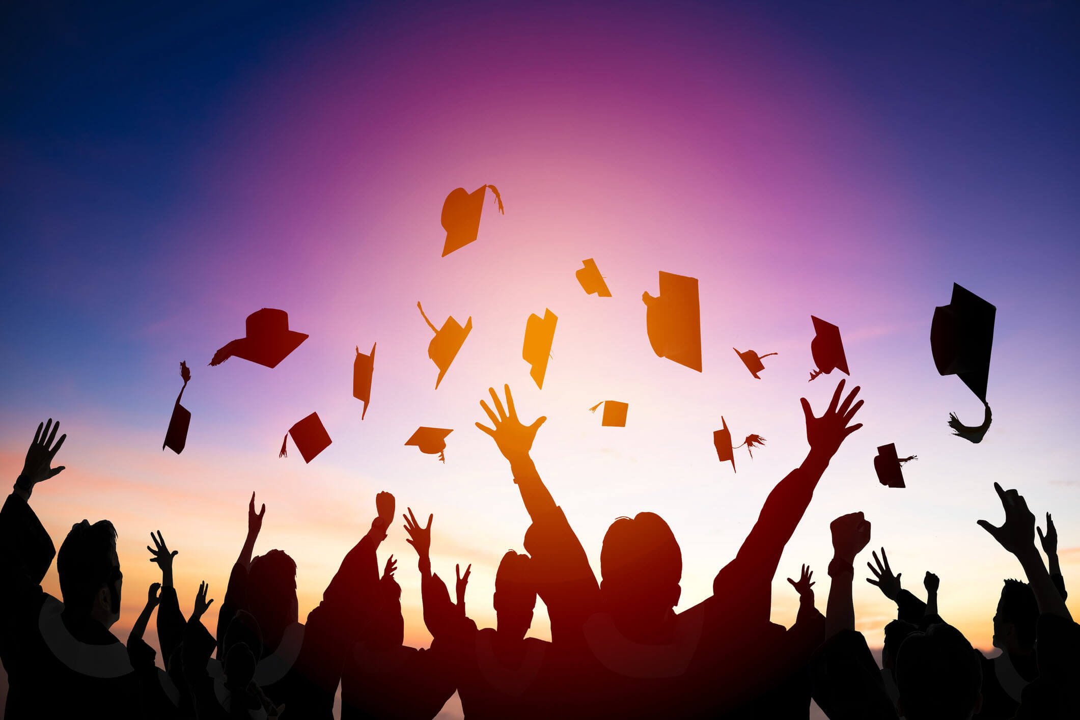 People throwing graduation caps in the air