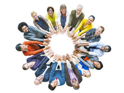 overhead view of people standing in a circle with their arms inward