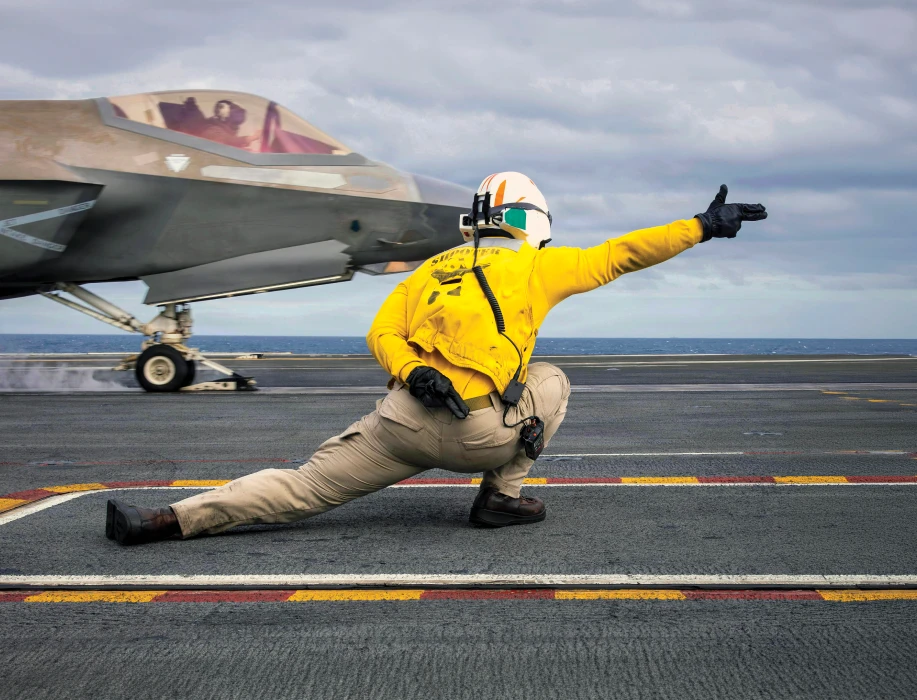 A person directing an airplane on the runway