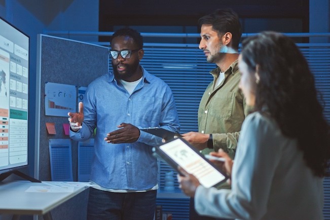 business professionals looking at AI projections on screen