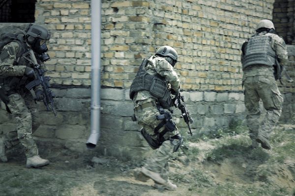 soldiers wearing camouflage raiding a building