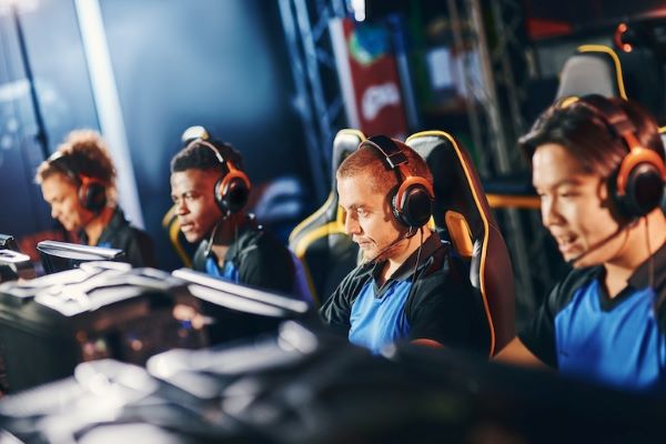 esports team sitting and computers wearing headsets