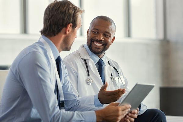 two male doctors talking and smiling