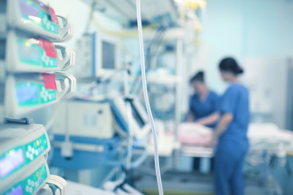 closeup of hospital monitors with nurses in the background