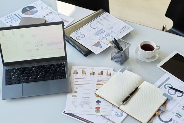cybercrime master's student's desk containing paperwork and coffee
