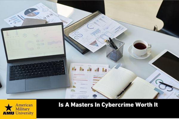 is-a-masters-in-cybercrime-worth-it cybercrime master's student's desk containing paperwork and coffee