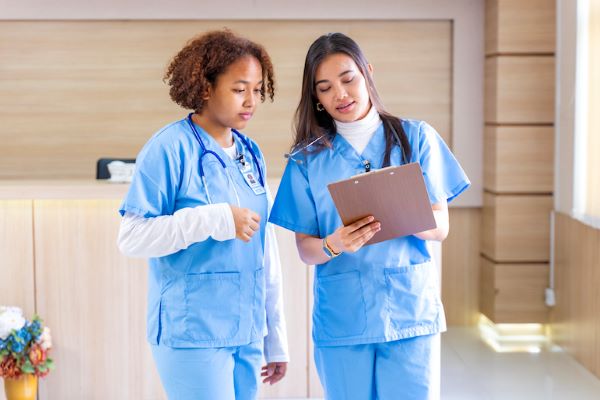 two female nursing looking at medical chart