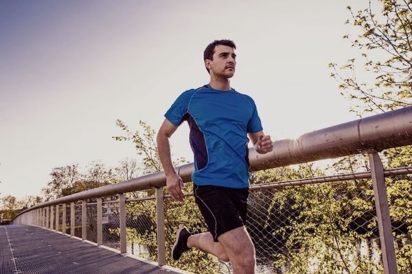 man jogging across bridge