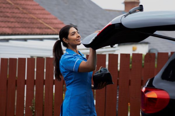 female nurse closing a car trunk