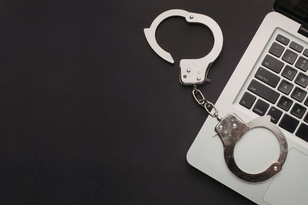 cybercrime depicted by handcuffs on keyboard