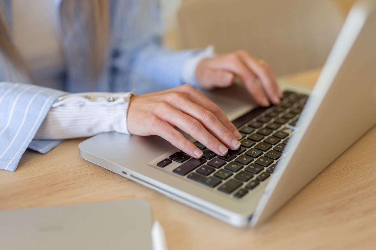 student typing on laptop